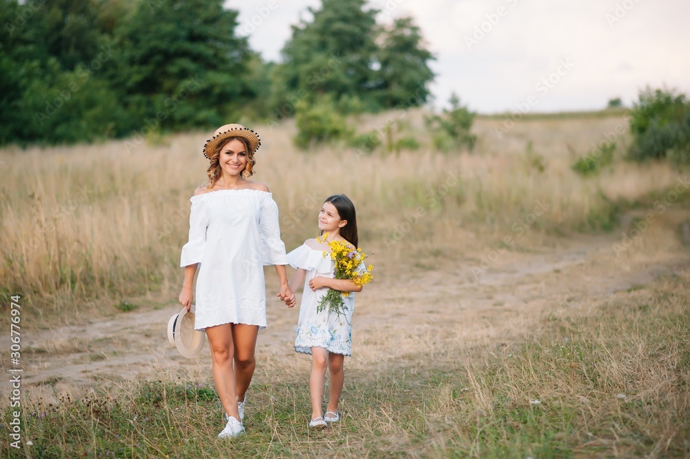 Mother and daughter having fun in the park. Happiness and harmony in family life. Beauty nature scene with family outdoor lifestyle. Mother's Day Mother and daughter having fun in the park. Happiness and harmony in family life. Beauty nature scene with family outdoor lifestyle. Mother's Day