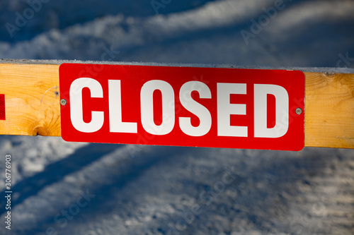 Red Closed sign on yellow barrier