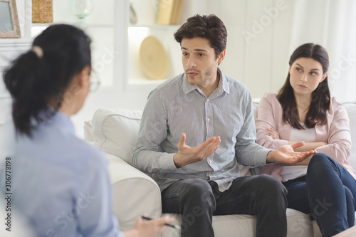 Young man explaining himself to family therapist © Prostock-studio