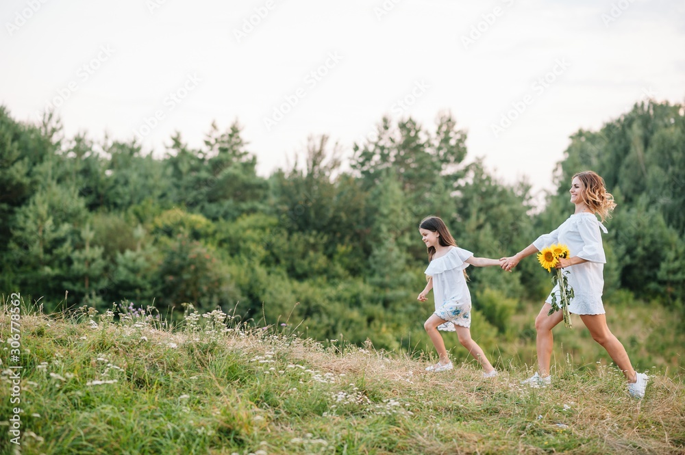 Mother and daughter having fun in the park. Happiness and harmony in family life. Beauty nature scene with family outdoor lifestyle. Mother's Day