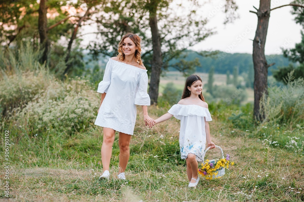 Fototapeta premium Stylish mother and handsome daughter having fun on the nature. Happy family concept. Beauty nature scene with family outdoor lifestyle. family resting together. Happiness in family life. Mothers day