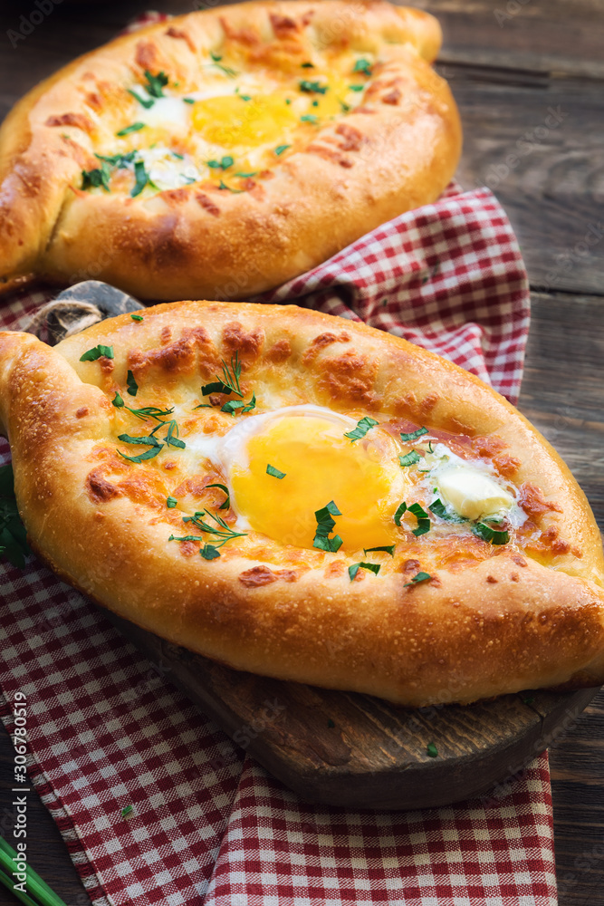 Khachapuri Ajarian on rustic wooden background Khachapuri Ajarian on rustic wooden background