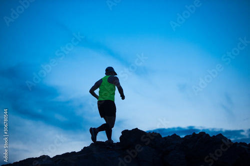 The man trail runner running at rocky mountain,man trail against the blue sky background, man and success in mountains