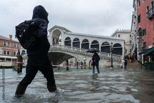 VENICE, ITALY - November 24, 2019: flood (acqua alta) in Venice, Italy. Venice high water. Tourists in Venice during a flood in Venice. Natural disaster. drama during the flood