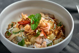 Rice noodles with shrimps and seafood, spicy asian style noodles in bowl.