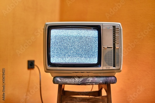 Vintage TV set on a chair in an empty room