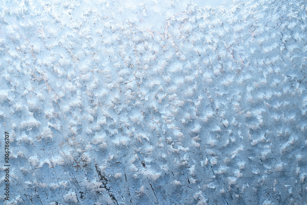 Obraz premium Surface of a winter frozen window is backlit by the sun outside, background, texture