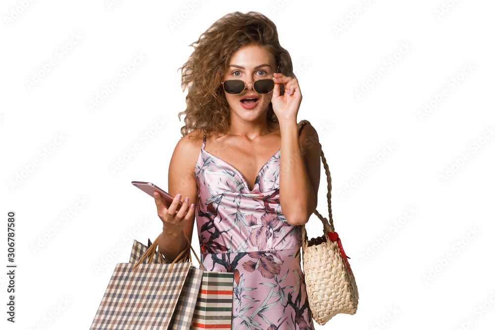 Obraz premium Gorgeous curly hair woman staying with shopping package and holding phone for online shopping. Black friday.