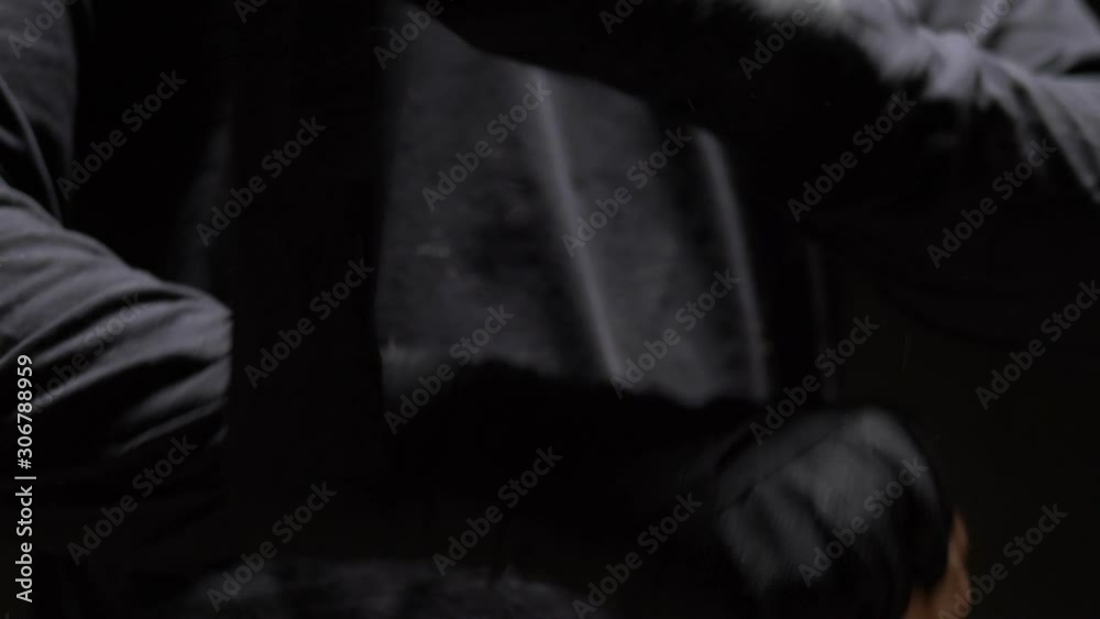 closeup. male hands wrapped around a black elastic bandage on hand. black background closeup. male hands wrapped around a black elastic bandage on hand. black background