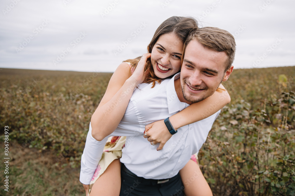 Obraz premium A girl and a guy are walking in the nature. Portrait of a couple, a love story.Happy smiling, loveing couple together outstretched at beautiful nature. Lovestory