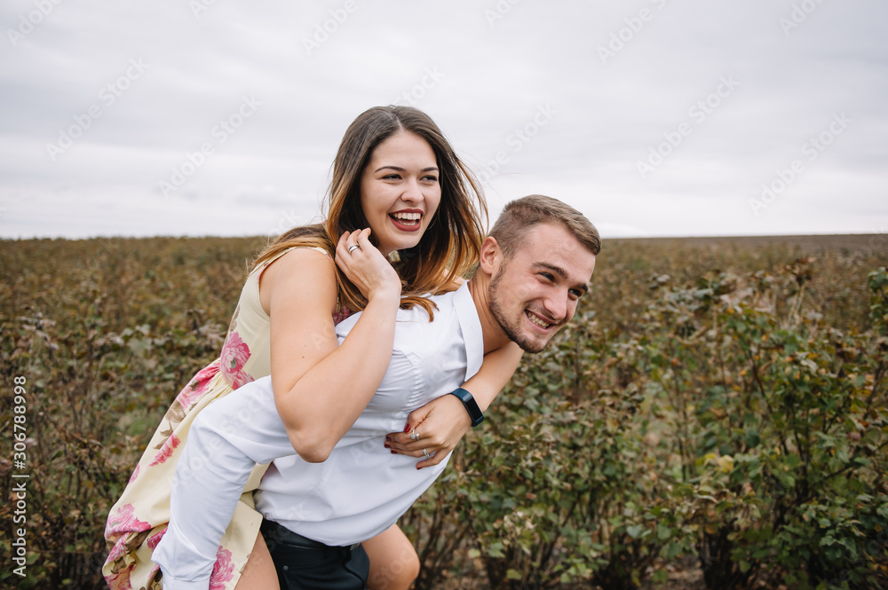 A girl and a guy are walking in the nature. Portrait of a couple, a love story.Happy smiling, loveing couple together outstretched at beautiful nature. Lovestory A girl and a guy are walking in the nature. Portrait of a couple, a love story.Happy smiling, loveing couple together outstretched at beautiful nature. Lovestory