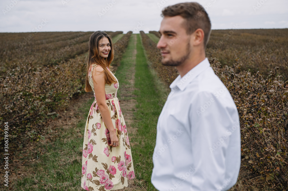 A girl and a guy are walking in the nature. Portrait of a couple, a love story.Happy smiling, loveing couple together outstretched at beautiful nature. Lovestory