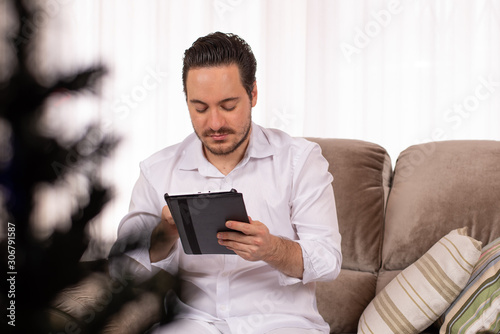 Serious man using tablet in christmas time