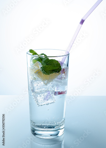 A glass of mineral water with an orange slice and mint