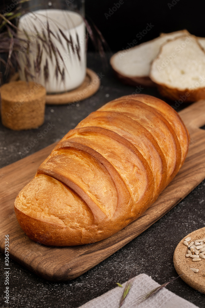 Loaf of fresh bread on a wooden board.