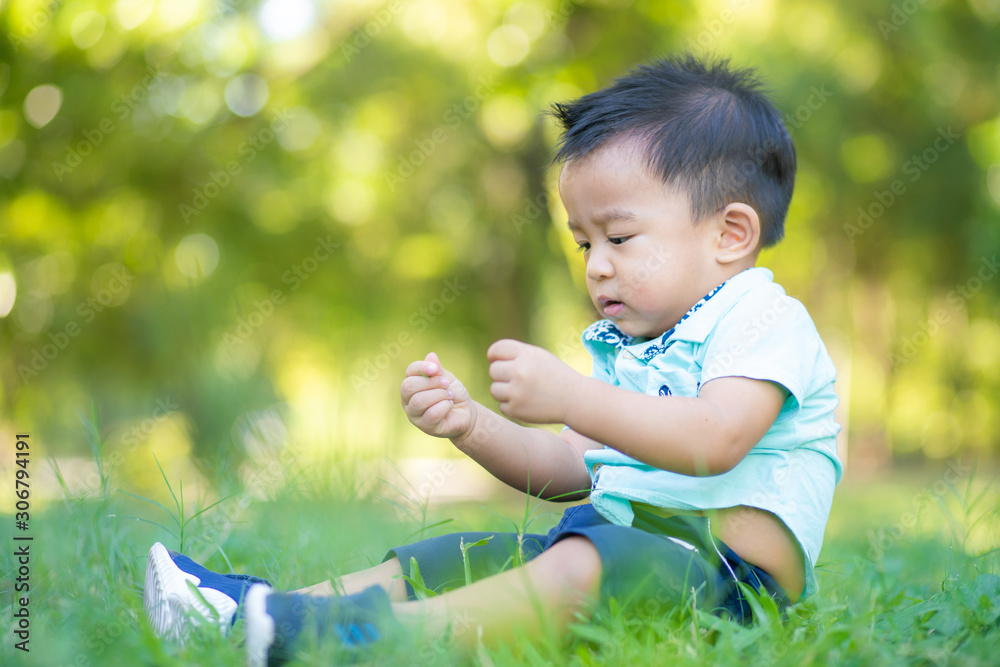 Adorable smart baby boy playing in city green park Adorable smart baby boy playing in city green park