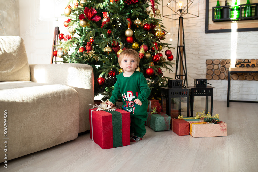 little boy playing with Christmas gift boxes