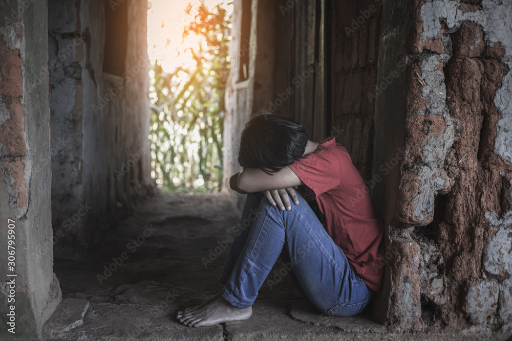 Young girl in despair sitting alone in old brick room. poor homeless concept Young girl in despair sitting alone in old brick room. poor homeless concept