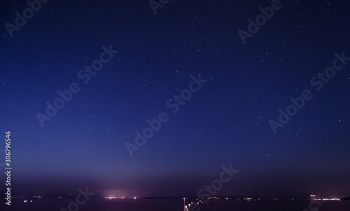 Seascape at night with settlement lights in the distance