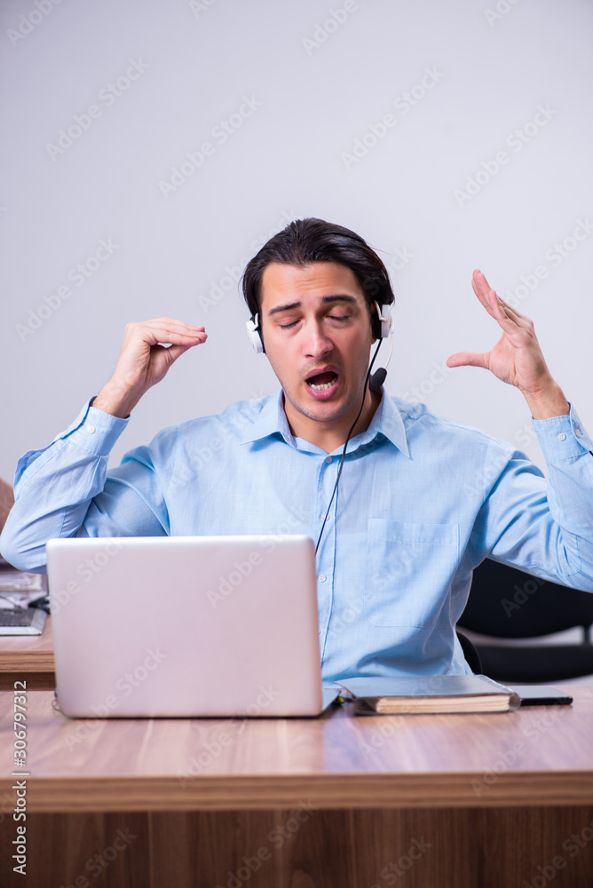 Call center operator working at his desk Call center operator working at his desk