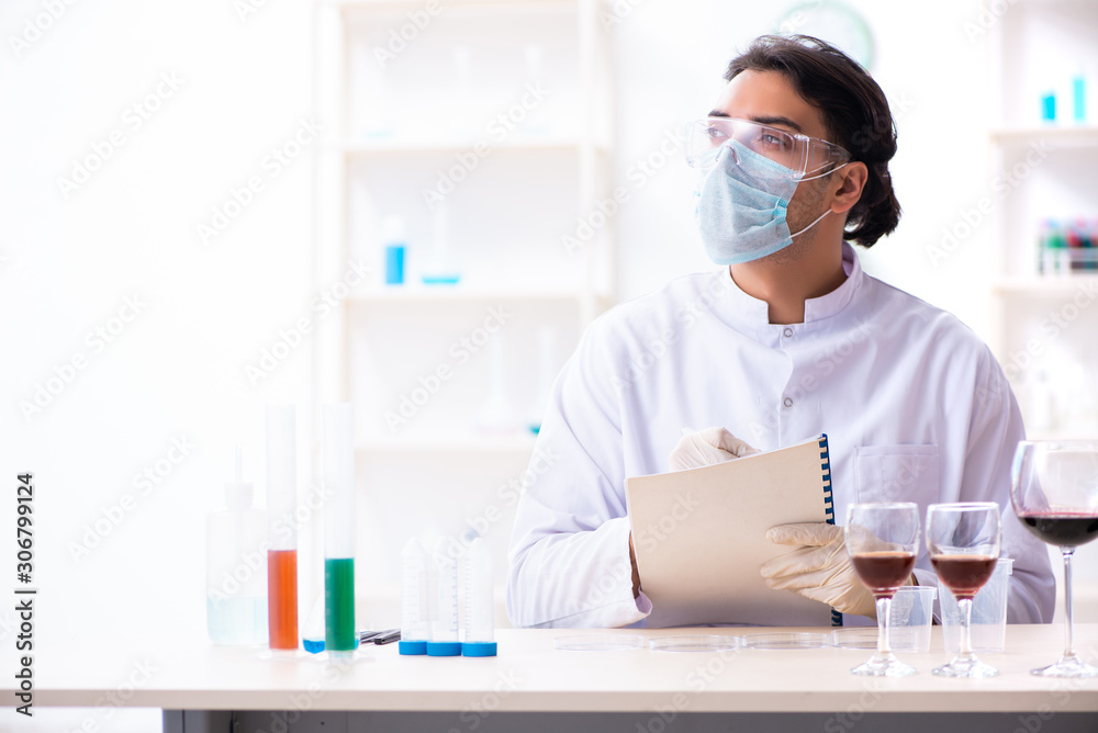 Male chemist examining wine samples at lab Male chemist examining wine samples at lab