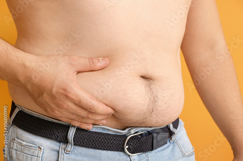 Overweight man touching fat...