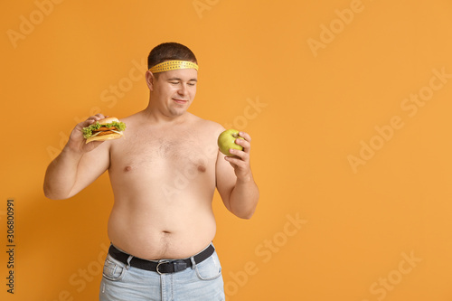 Overweight man with burger ...