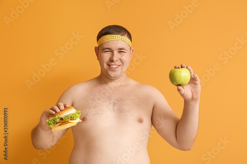 Overweight man with burger ...