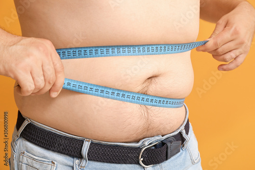 Overweight man measuring hi...