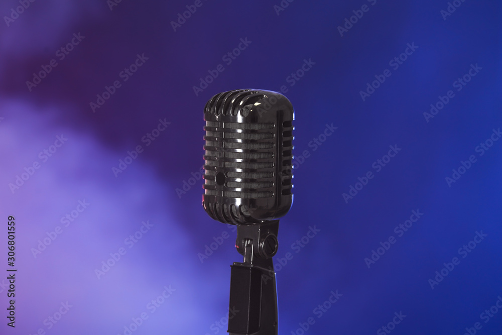Fototapeta premium Retro microphone on dark color background with smoke