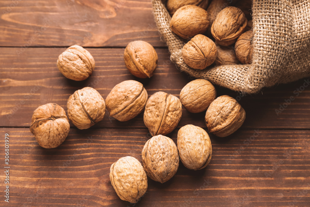 Sack with tasty walnuts on wooden table Sack with tasty walnuts on wooden table