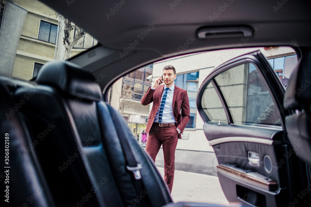 Man in suit speaking on mobile near the luxury car Man in suit speaking on mobile near the luxury car