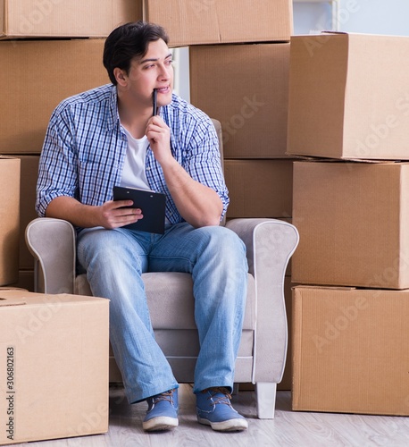 The young man moving in to new house with boxes