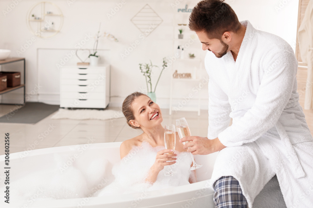 Happy young couple drinking champagne in bathroom Happy young couple drinking champagne in bathroom