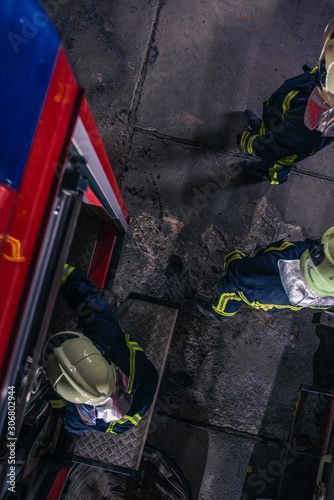 Firemen checking the fire engine inside the fire department from a bird perspective