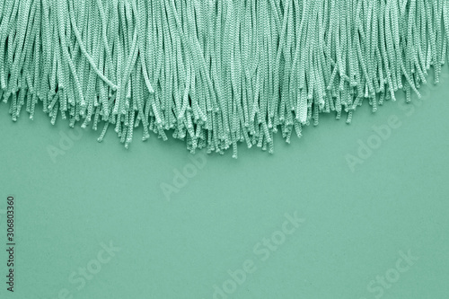 Turquoise tassels on color background