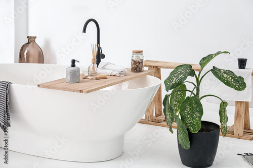 Fototapeta Bathtub with supplies in stylish interior