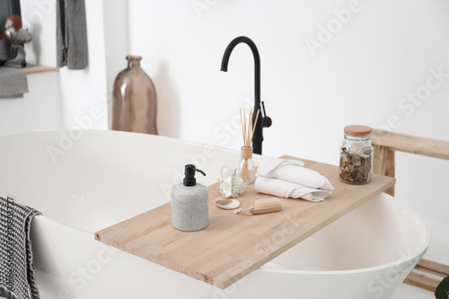 Fotografia Bathtub with supplies in stylish interior