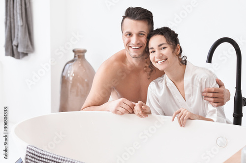 Happy young couple in bathr...