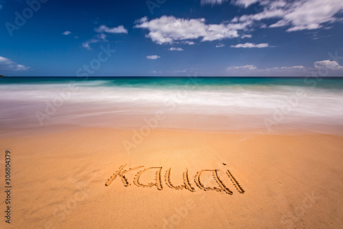 The word Kauai written on the sand of a beach in Kauai, Hawaii photo