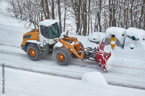 Snowplow machine clearing snow from roads after heavy snowfall in the Alps