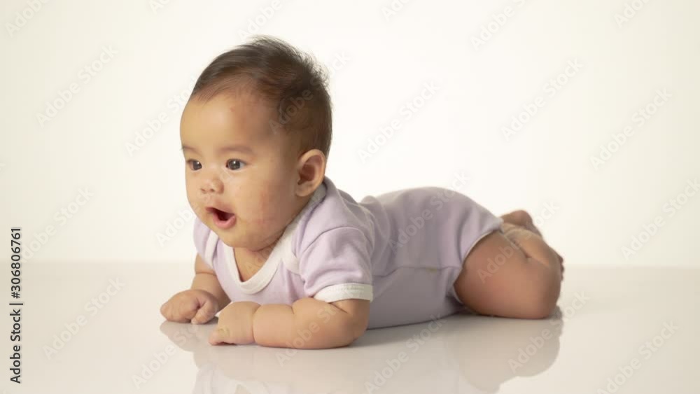 baby laying on her belly. tummy time cute baby in studio portrait baby laying on her belly. tummy time cute baby in studio portrait