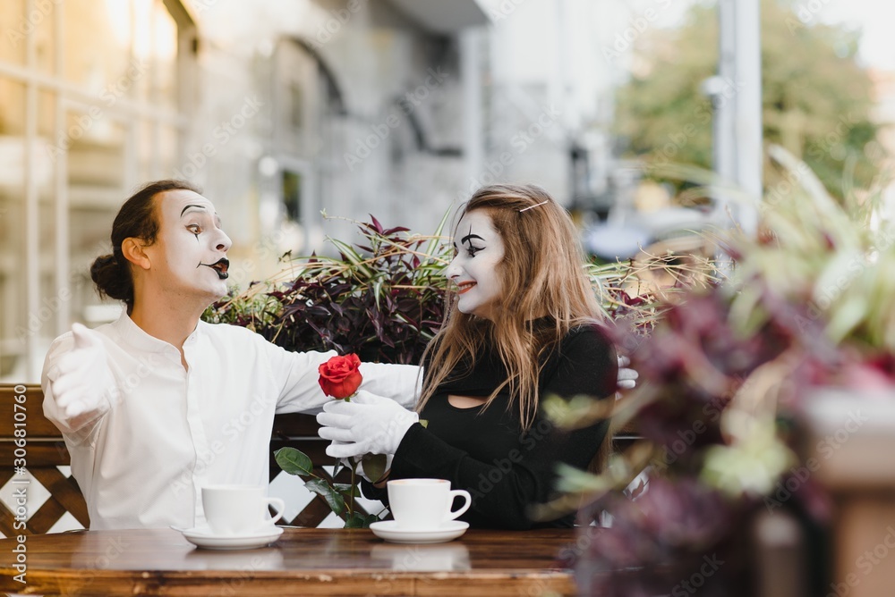 mime guy and girl in cafe drinking coffee. Mime in front of Paris cafe acting like drinking tea or coffee. mime guy and girl in cafe drinking coffee. Mime in front of Paris cafe acting like drinking tea or coffee.