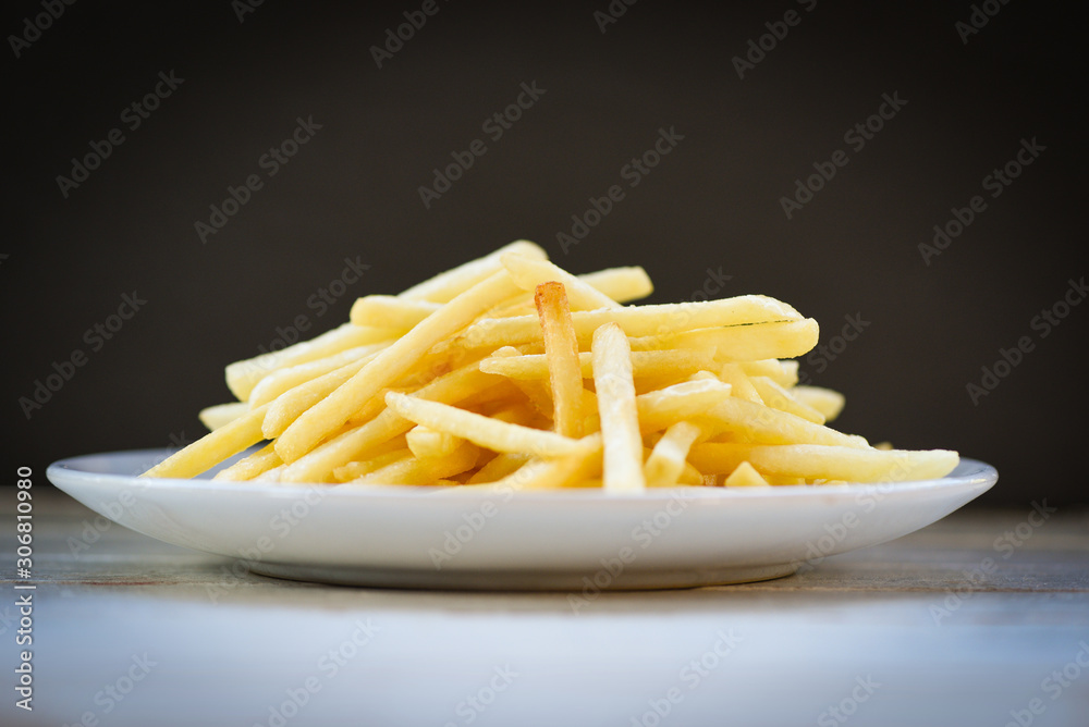 Fresh french fries in white plate with black background - Tasty potato fries for food or snack delicious Italian meny homemade ingredients