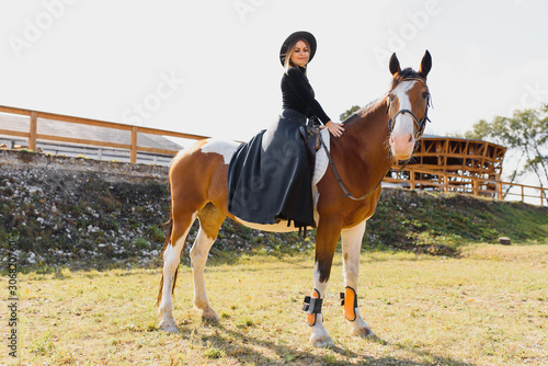 Fashionable portrait of a beautiful young woman and horse