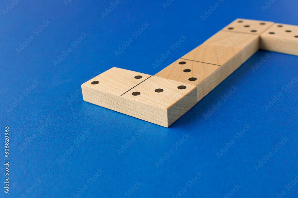 Playing dominoes on a blue background. Leisure games concept. Domino effect.