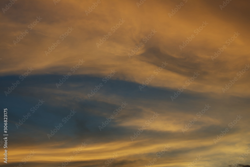 Naklejka premium Blue sky hole that surrounding by glowing orange cloud in an evening