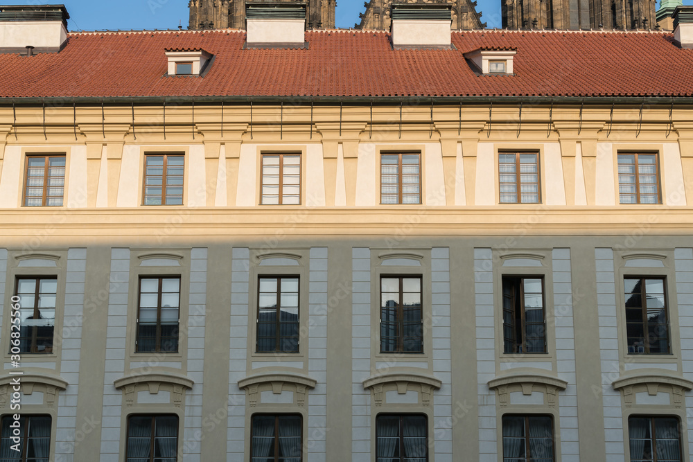 Wall background of old city buildings in Prague, Czech Republic, walls of retro buildings and red tile roofs