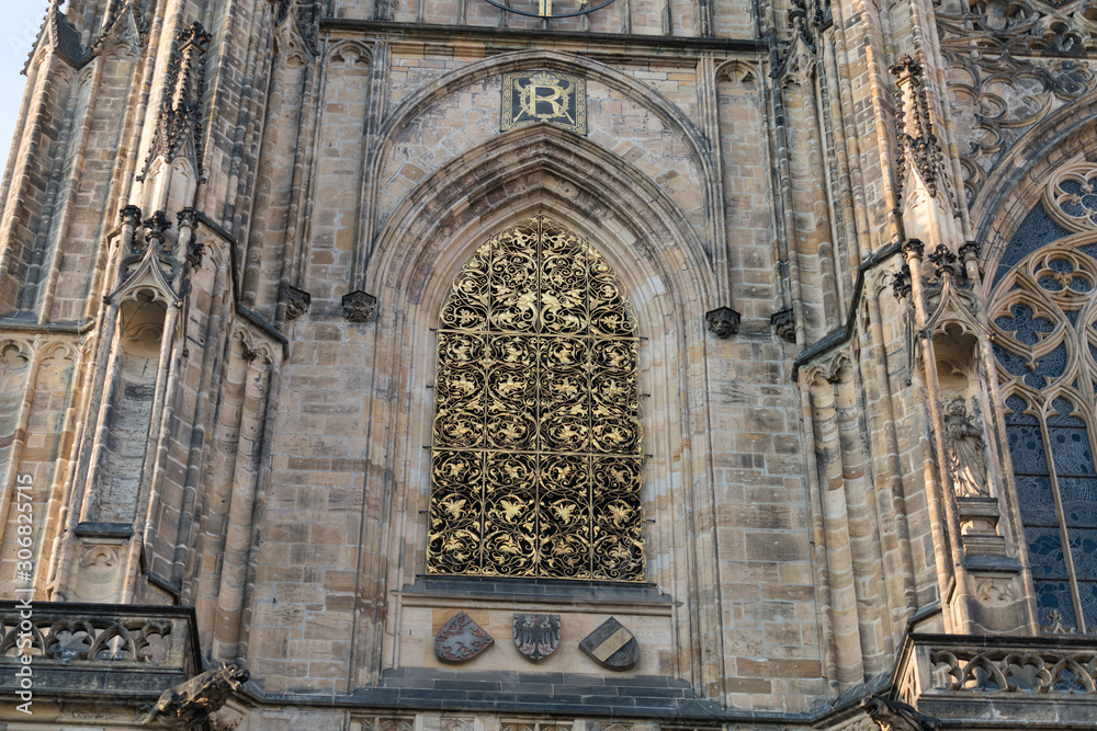 Details of the architecture of Metropolitan Cathedral of Saints Vitus in Prague, Czech Republic. Gothic style building with ancient glass window and tower.