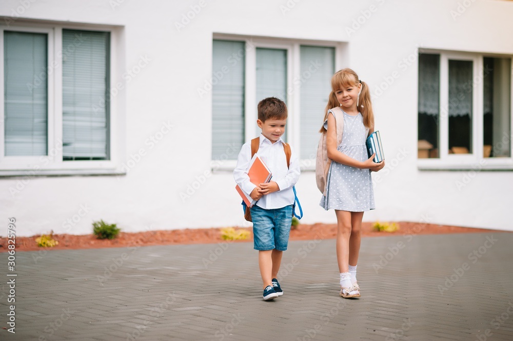 Two little friends go to school. Schoolchildren. back to school Two little friends go to school. Schoolchildren. back to school
